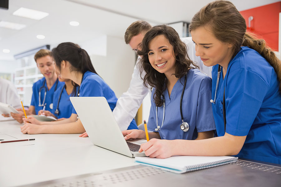 Smiling medical students looking at a computer