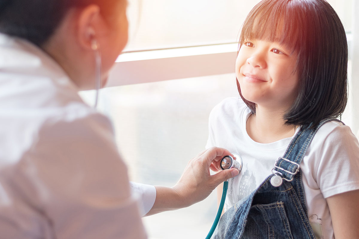 A doctor checking a child's hearbeat with a stethoscope