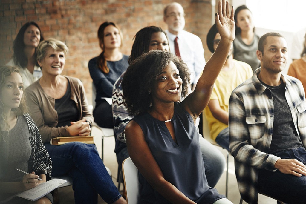 Woman raising her hand in an audience