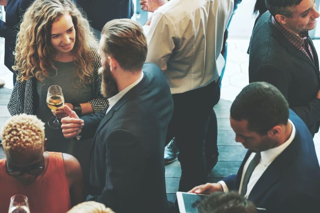 A room of people talking at a networking event.