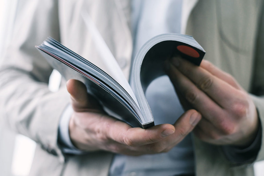 Man's hands holding open book