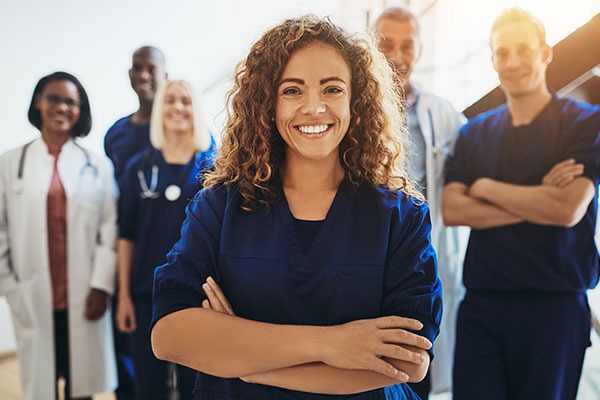 Smiling woman with doctors behind her